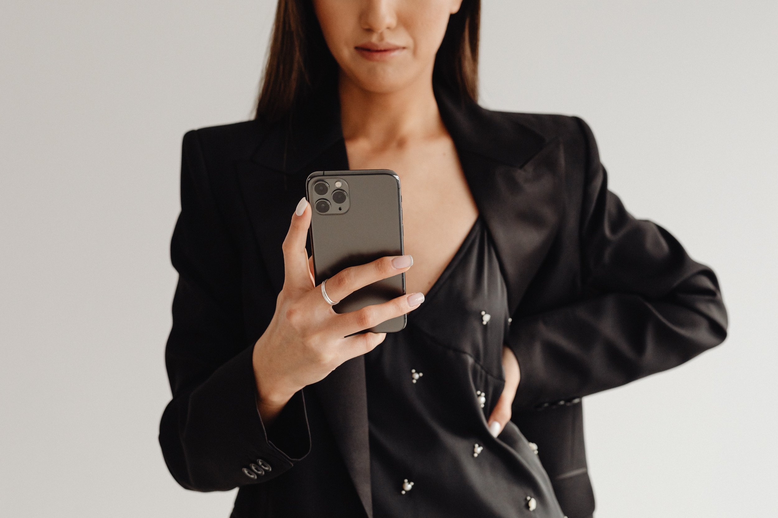 kaboompics_dark-classy-aesthetic-fashion-beautiful-asian-female-entrepreneur-in-black-suit-technology-and-devices-iphone-laptop-airpods-30092